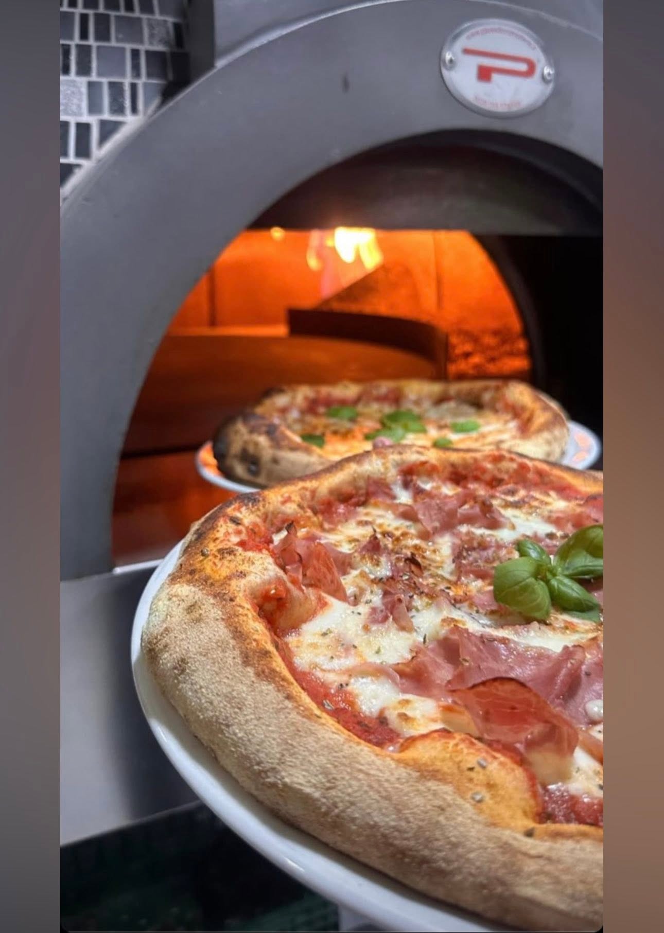 Pizza devant le four à bois