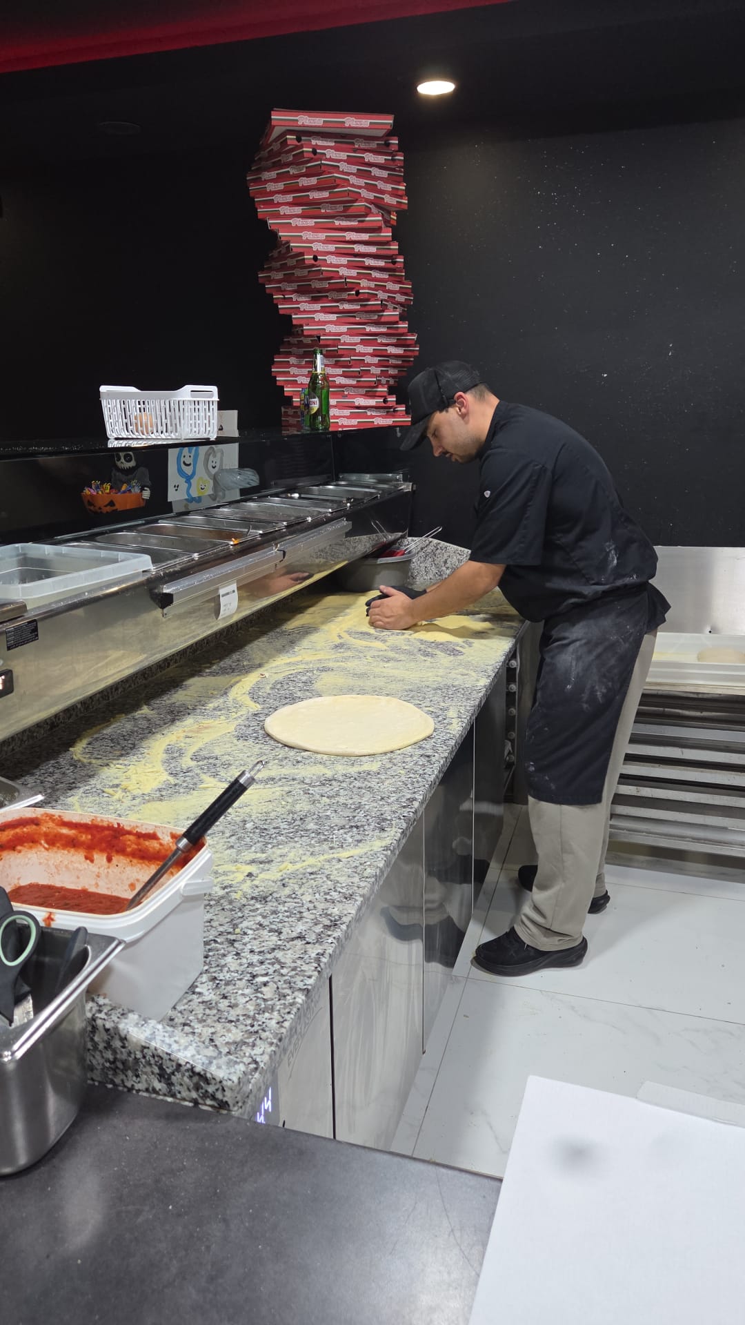 Gino étale la pâte à pizza